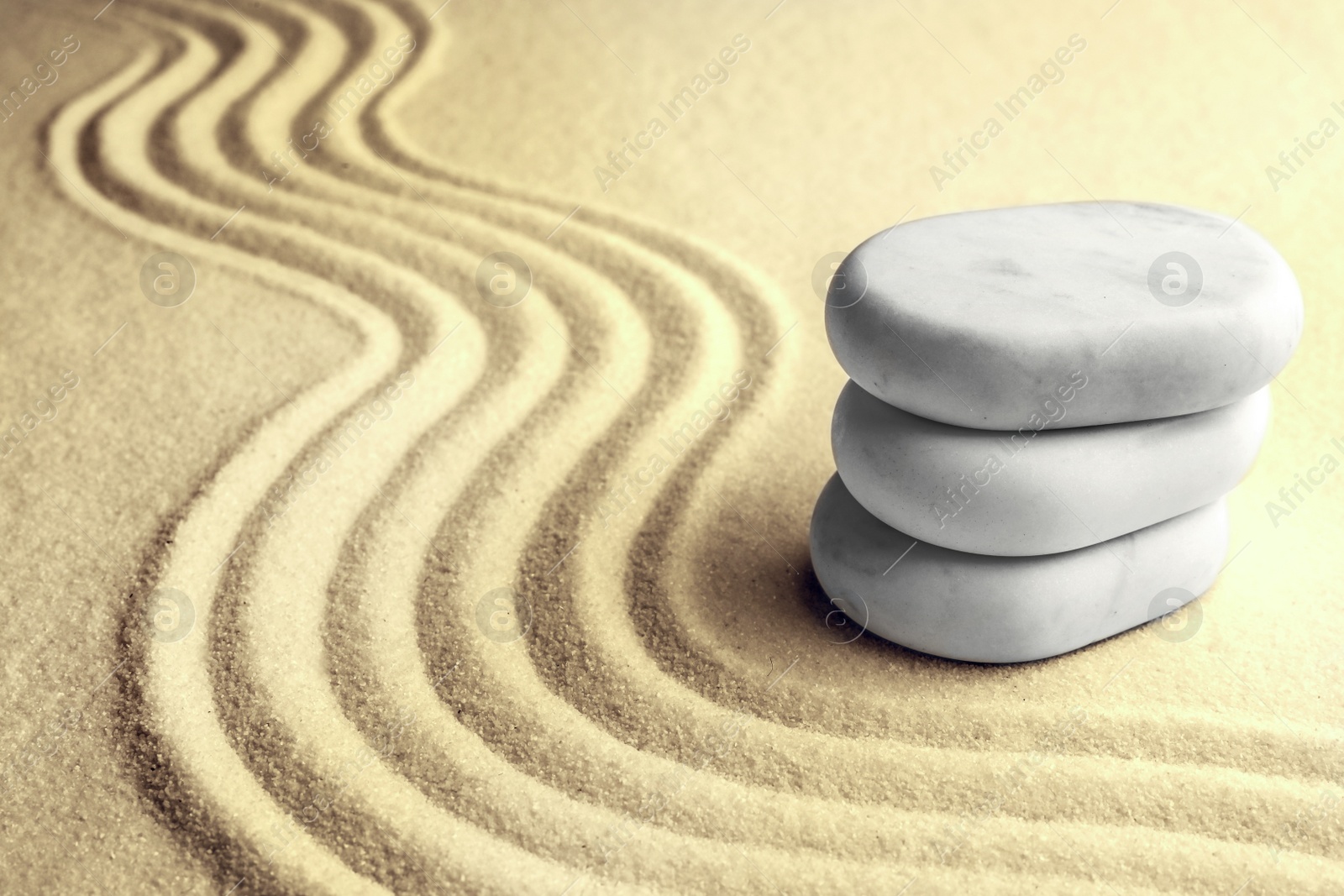 Image of Stack of white stones on sand with pattern, space for text. Zen, meditation, harmony