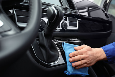 Photo of Car wash worker cleaning automobile interior, closeup