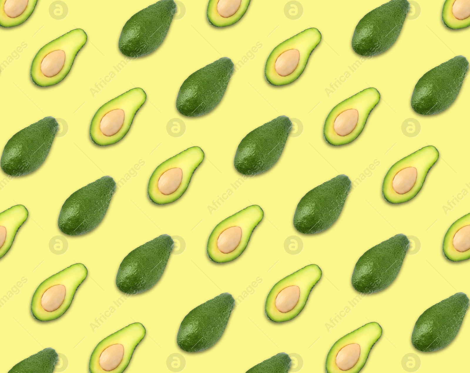Image of Pattern of whole and halved avocados on pale yellow background