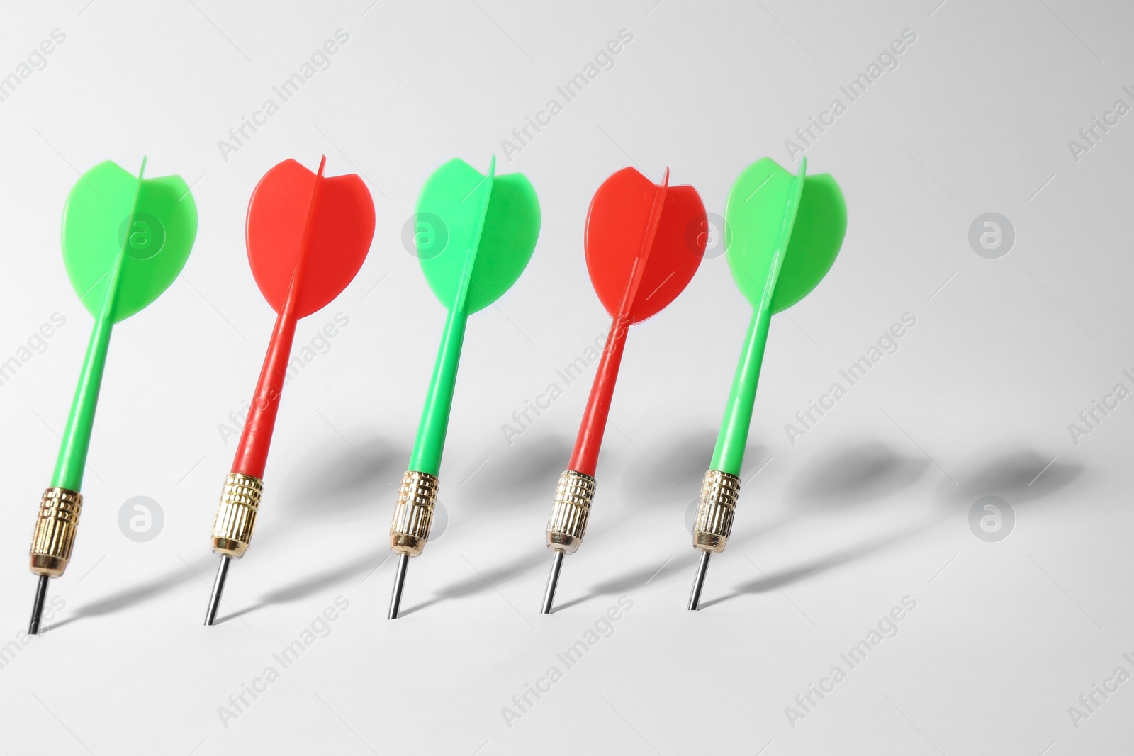 Photo of Bright color dart arrows for game on white background