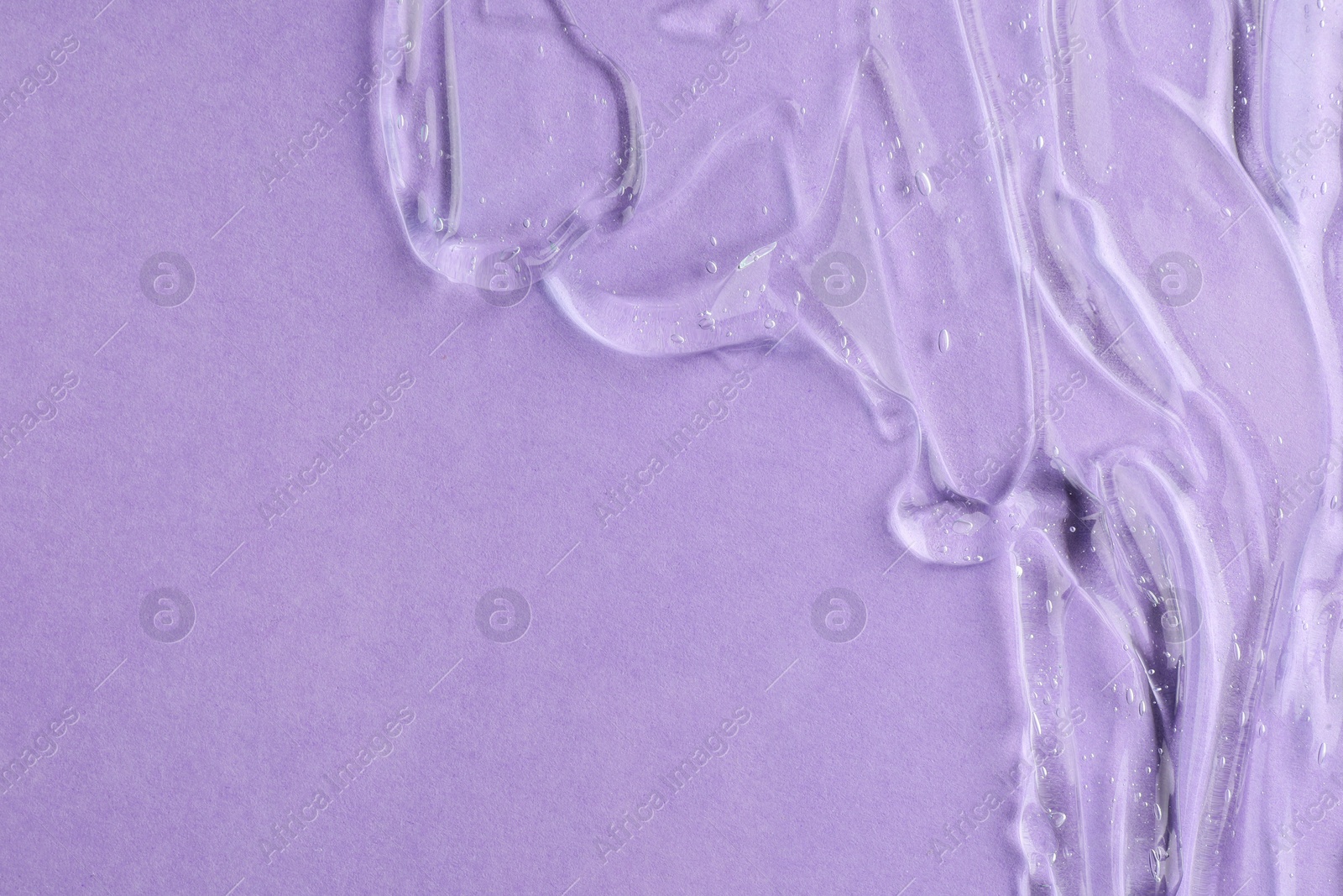 Photo of Clear cosmetic gel on violet background, top view. Space for text