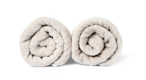 Photo of Rolled clean beige towels on white background