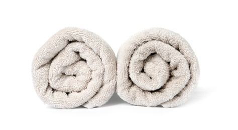 Rolled clean beige towels on white background