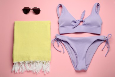 Photo of Beach towel, swimsuit and sunglasses on pink background, flat lay