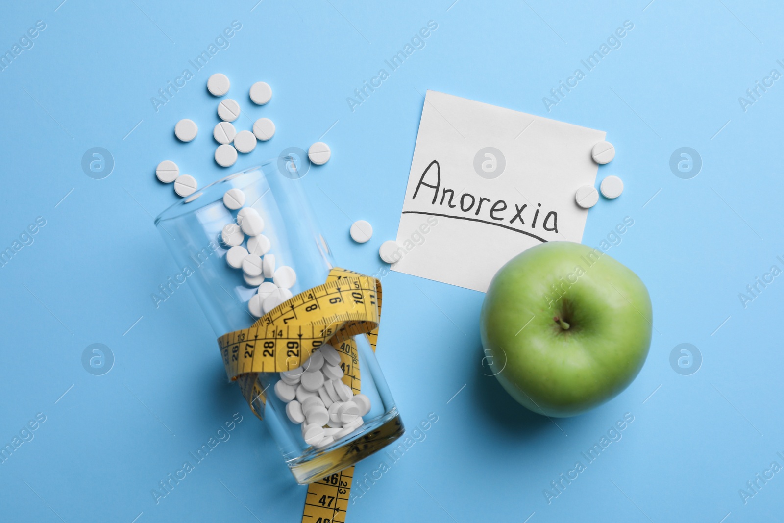 Photo of Flat lay composition with word Anorexia on light blue background