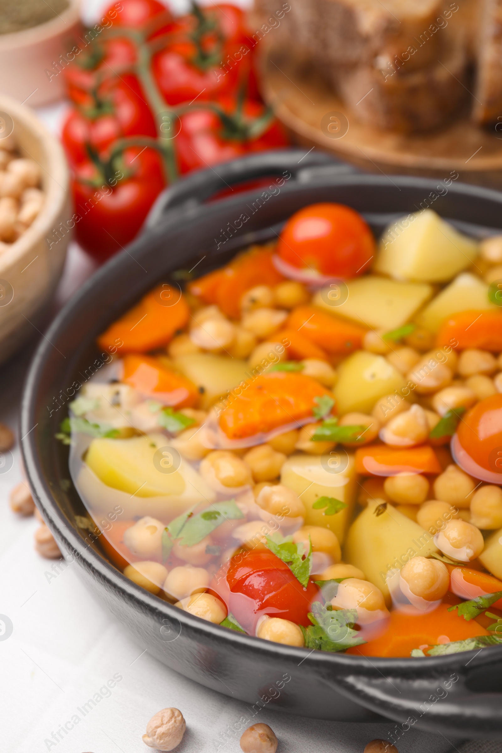 Photo of Tasty chickpea soup on white tiled table, closeup