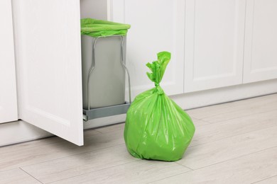 Photo of Plastic garbage bag and trash can indoors