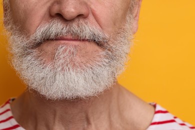 Photo of Man with mustache on orange background, closeup