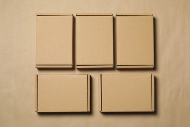 Photo of Many closed cardboard boxes on light brown background, flat lay