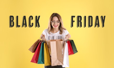 Black Friday Sale. Beautiful young woman with shopping bags on yellow background