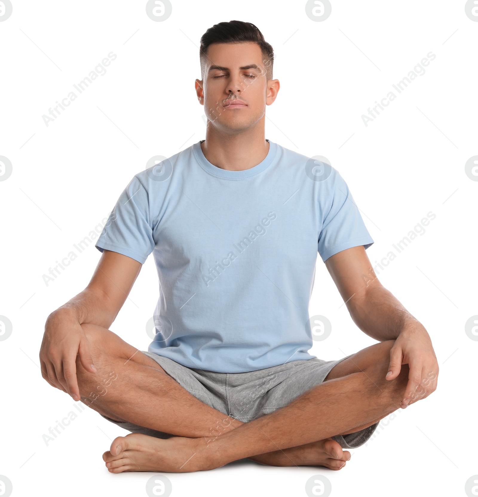 Photo of Handsome man meditating on white background. Harmony and zen