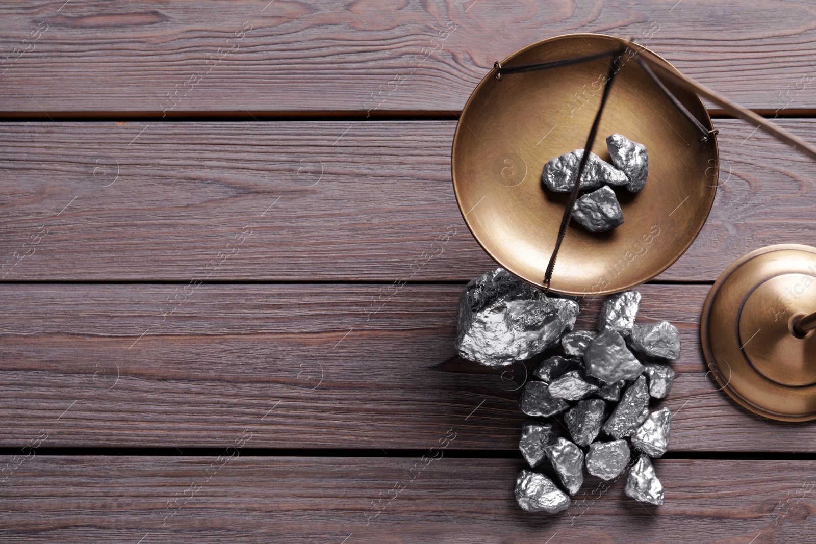 Photo of Vintage scales with silver nuggets on wooden table, flat lay. Space for text