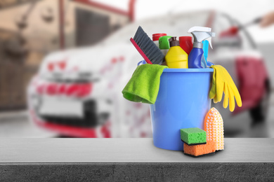 Image of Bucket with cleaning supplies on grey stone surface at car wash. Space for text