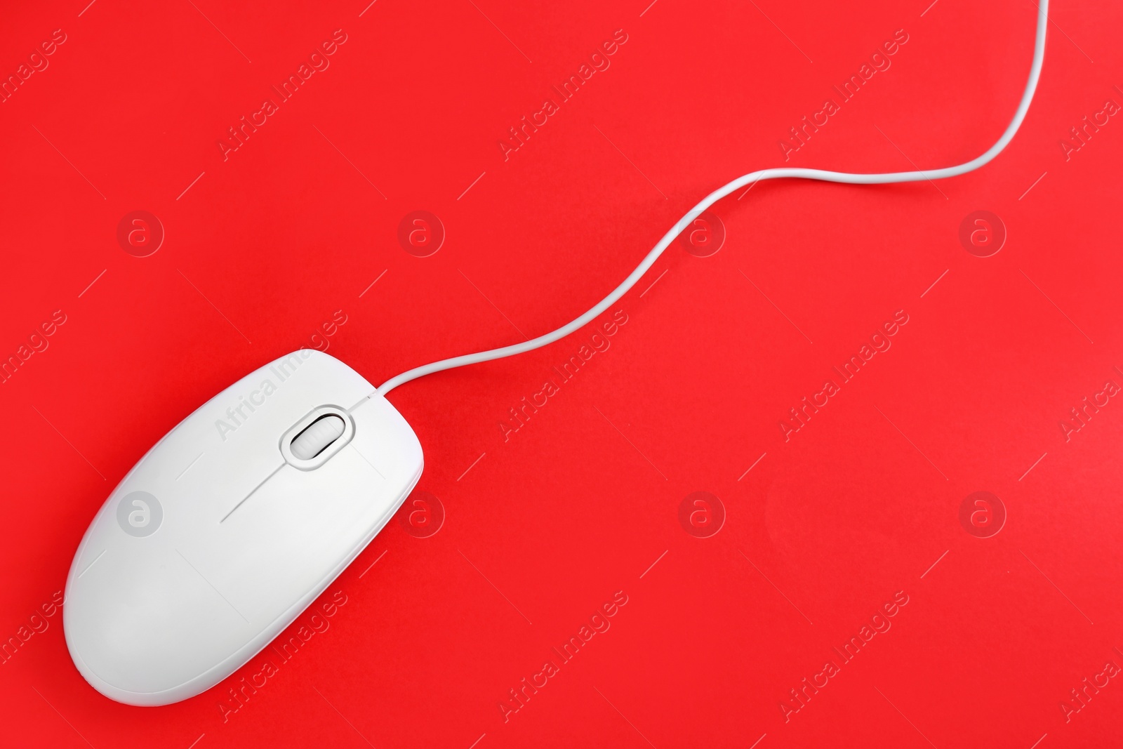 Photo of Modern wired optical mouse on red background, top view