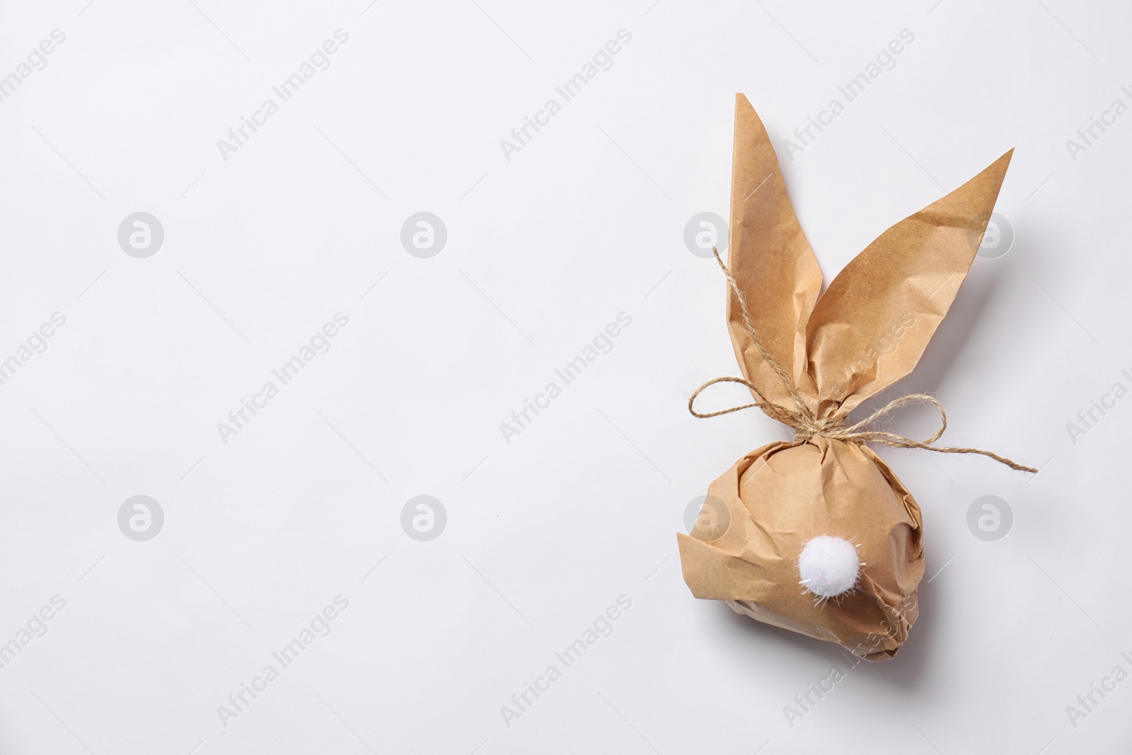 Photo of Creative Easter bunny gift bag on white background, top view