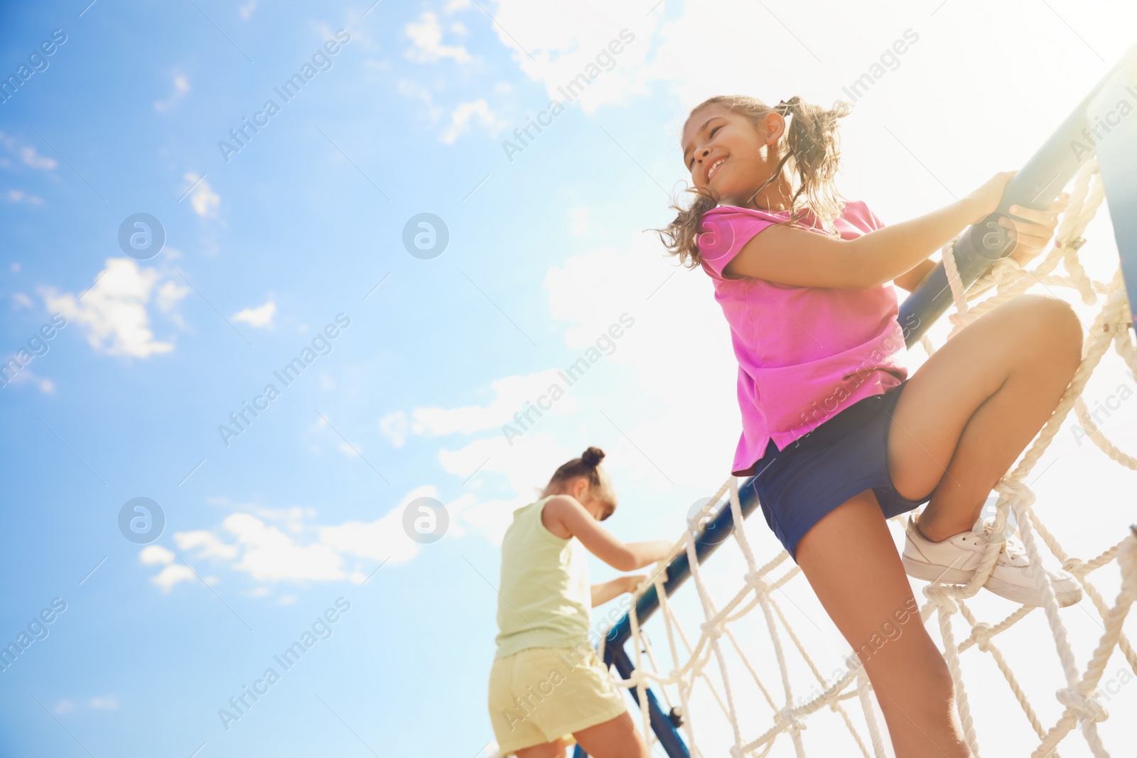 Photo of Cute children on playground rope climber outdoors. Summer camp