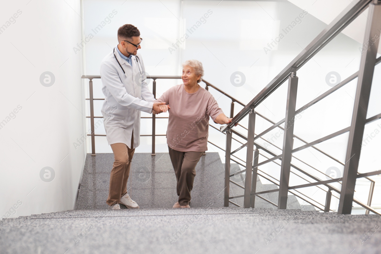 Photo of Doctor helping senior patient in modern hospital