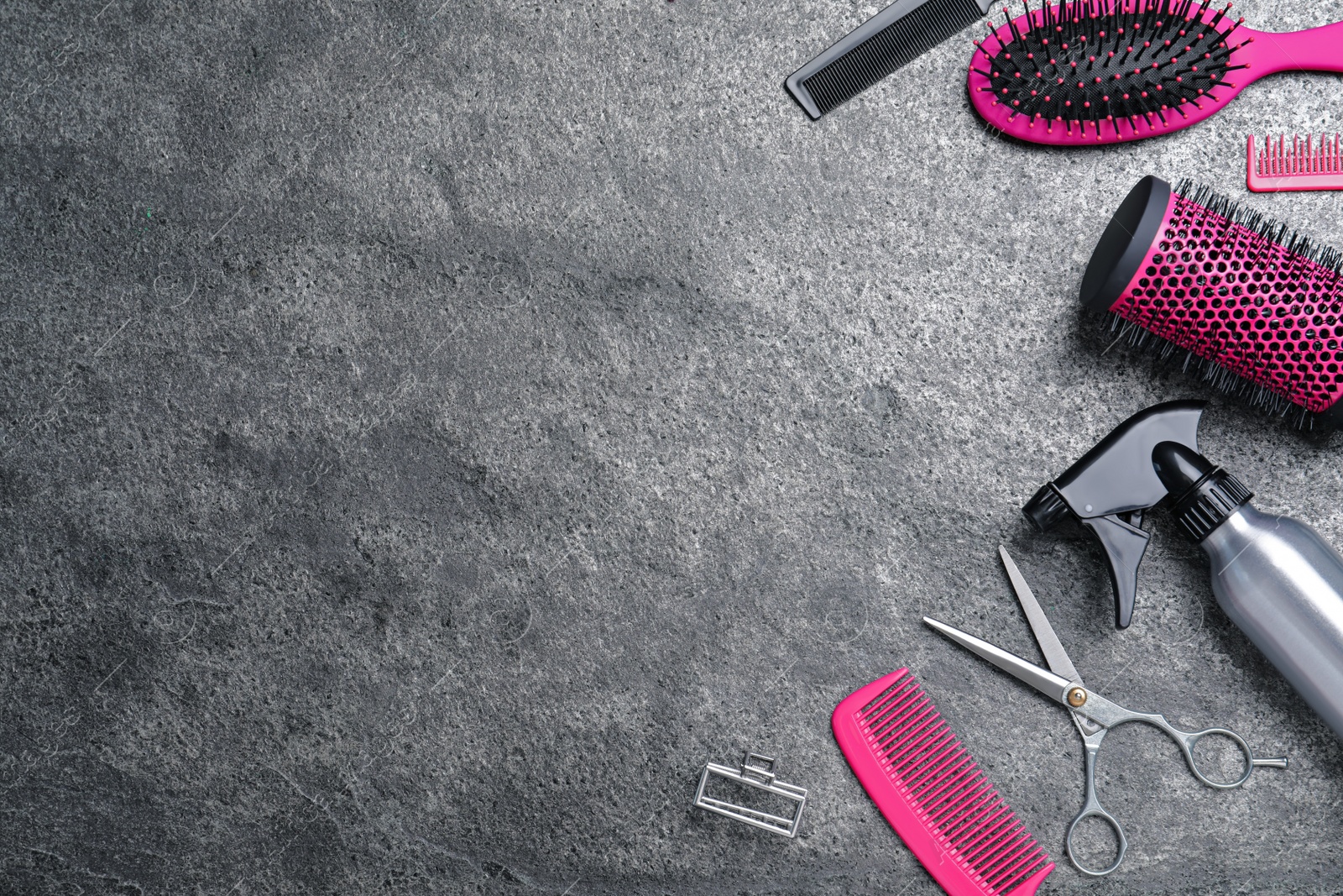 Photo of Flat lay composition of professional scissors and other hairdresser's equipment on grey table, space for text. Haircut tool