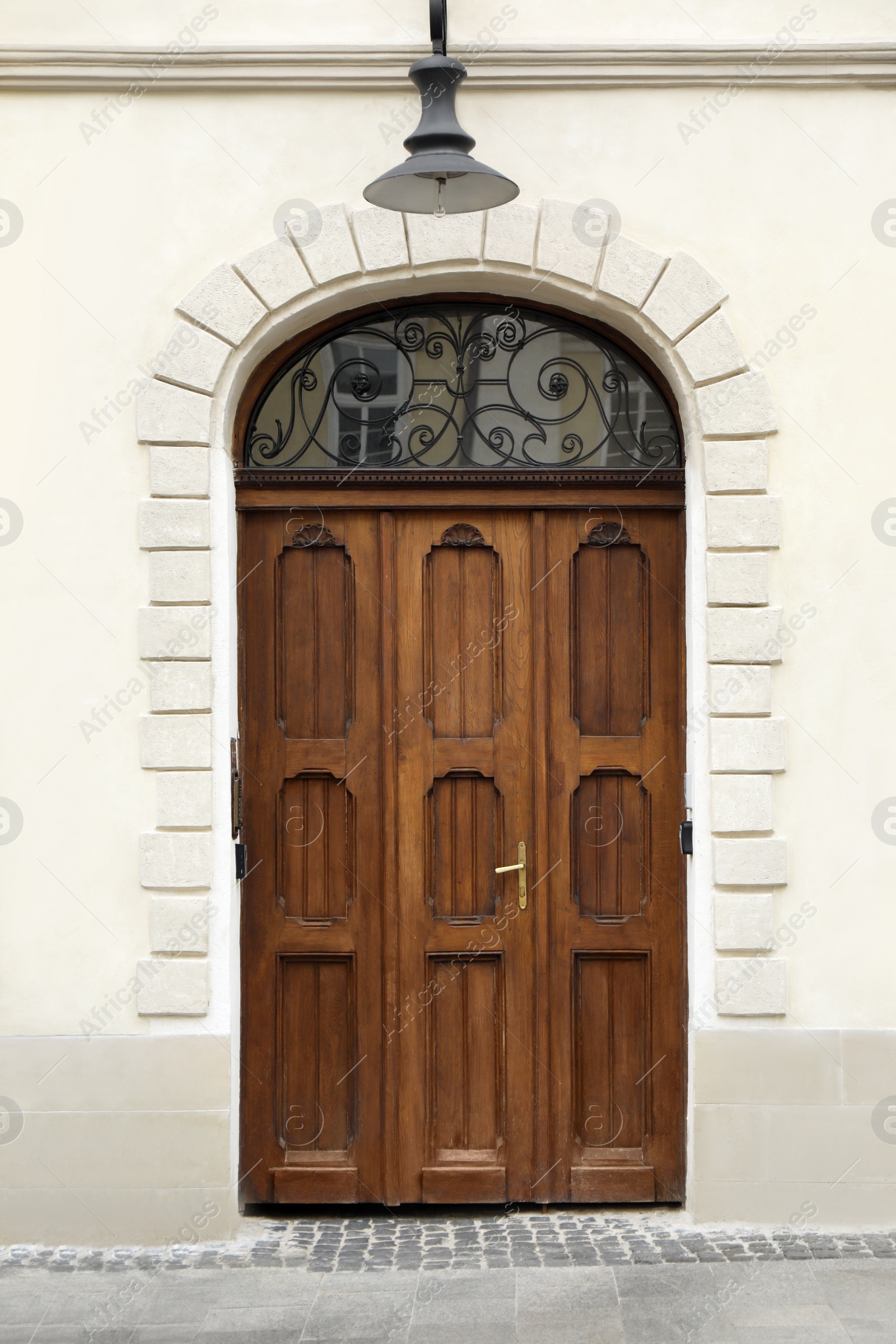 Photo of View of house with beautiful arched wooden door. Exterior design