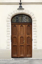 View of house with beautiful arched wooden door. Exterior design