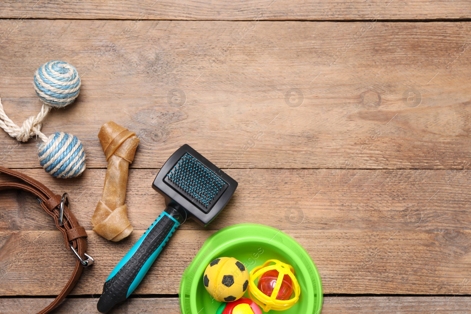 Photo of Pet toys, bowl and accessories on wooden table, flat lay. Space for text