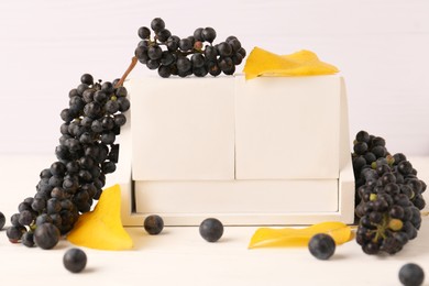 Photo of Thanksgiving day, holiday celebrated every fourth Thursday in November. Block calendar, yellow leaves and berries on white wooden table