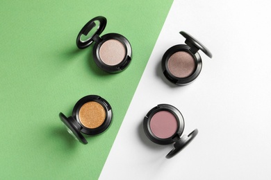 Photo of Flat lay composition with different eye shadows on color background