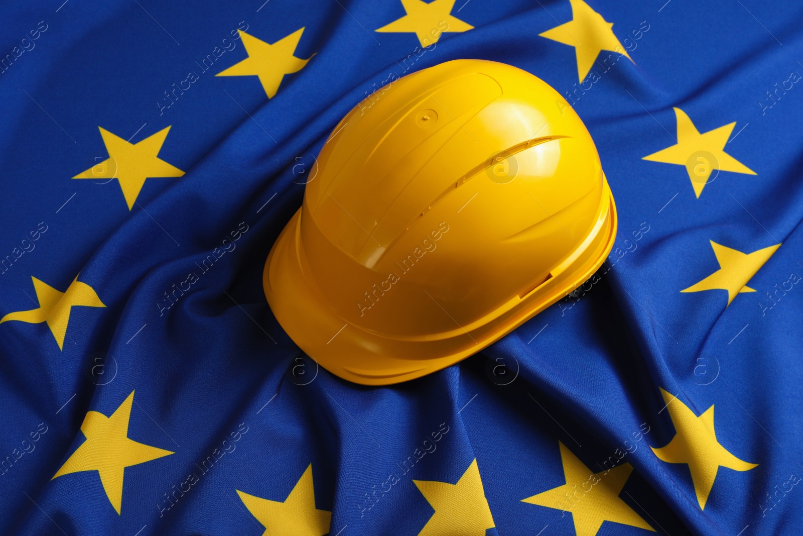 Photo of Yellow hard hat on European Union flag