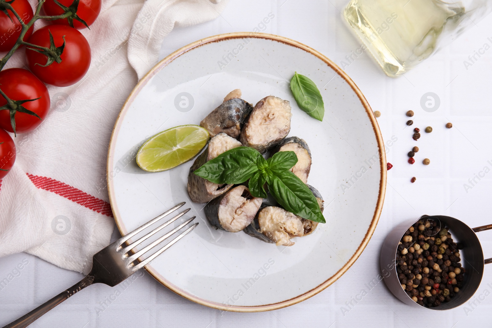 Photo of Canned mackerel chunks served on white tiled table, flat lay