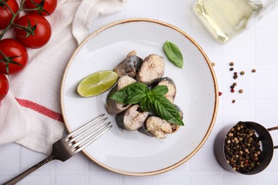 Photo of Canned mackerel chunks served on white tiled table, flat lay