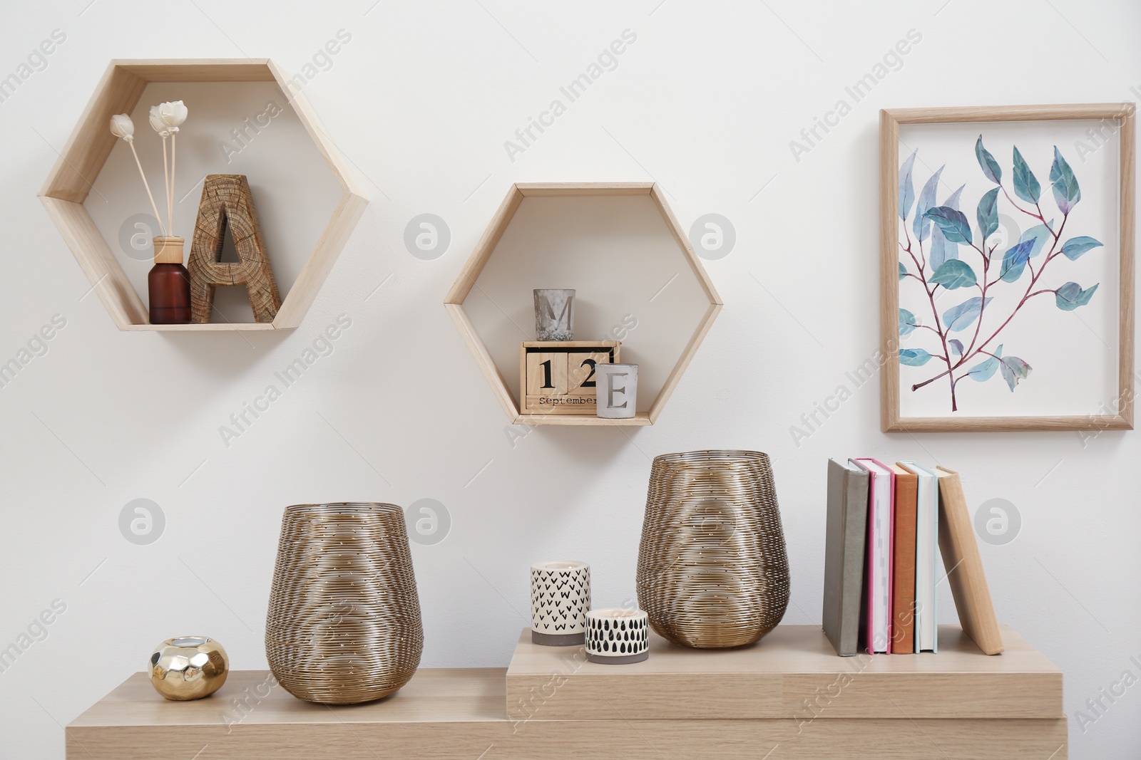 Photo of Wooden table with books and decor near light wall. Interior element