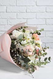 Photo of Bouquet of beautiful flowers on white wooden table, closeup