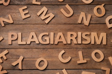 Photo of Word Plagiarism made of wooden letters on table, flat lay