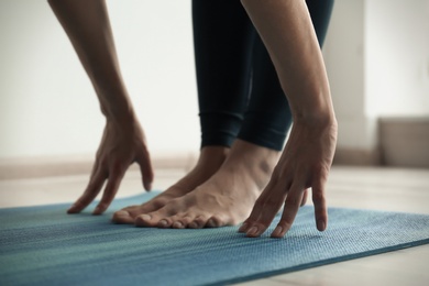 Photo of Young woman practicing yoga indoors, closeup