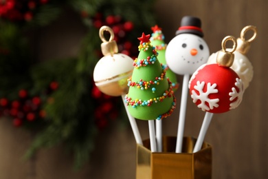 Delicious Christmas themed cake pops on wooden background, closeup