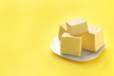 Plate with fresh butter on color background. Space for text