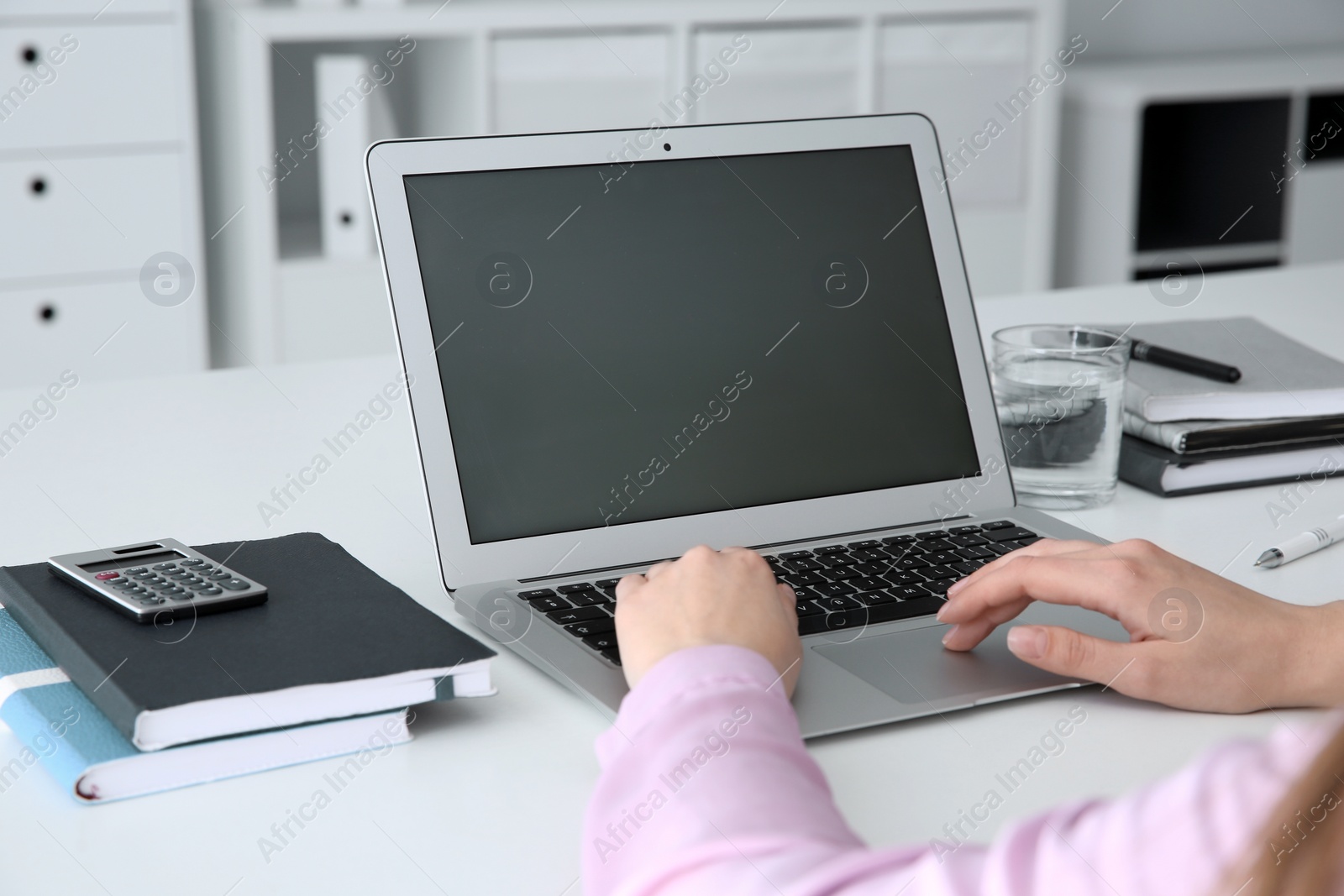 Photo of Young woman using modern laptop at table, closeup