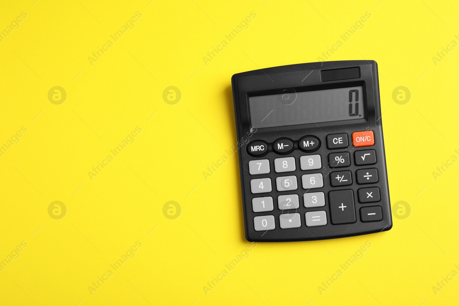 Photo of Calculator on yellow background, top view. Space for text