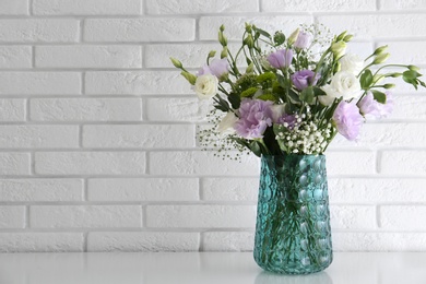 Bouquet of beautiful Eustoma flowers on white table. Space for text