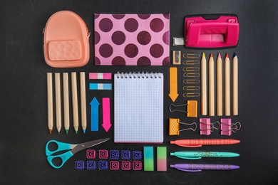 Photo of Flat lay composition with different school stationery on chalkboard surface