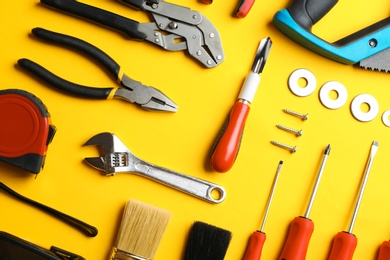 Photo of Flat lay composition with construction tools on color background