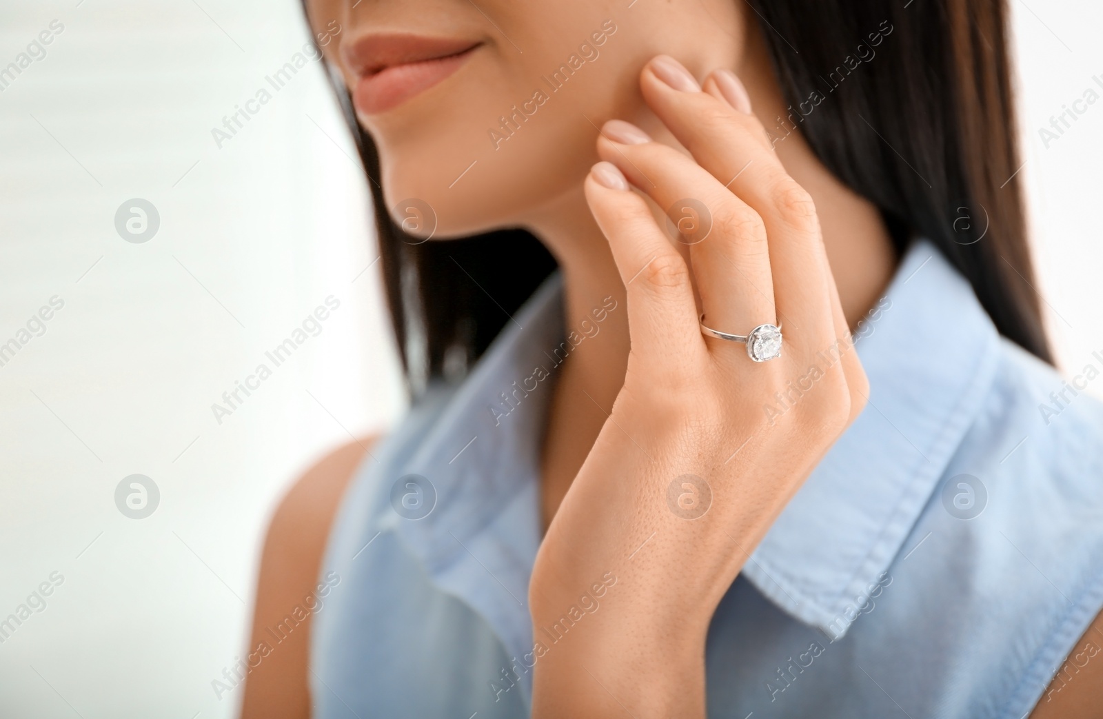 Photo of Young woman wearing beautiful engagement ring, closeup