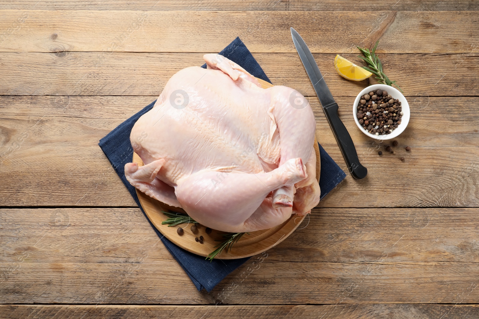 Photo of Fresh raw chicken with spices and knife on wooden table, flat lay