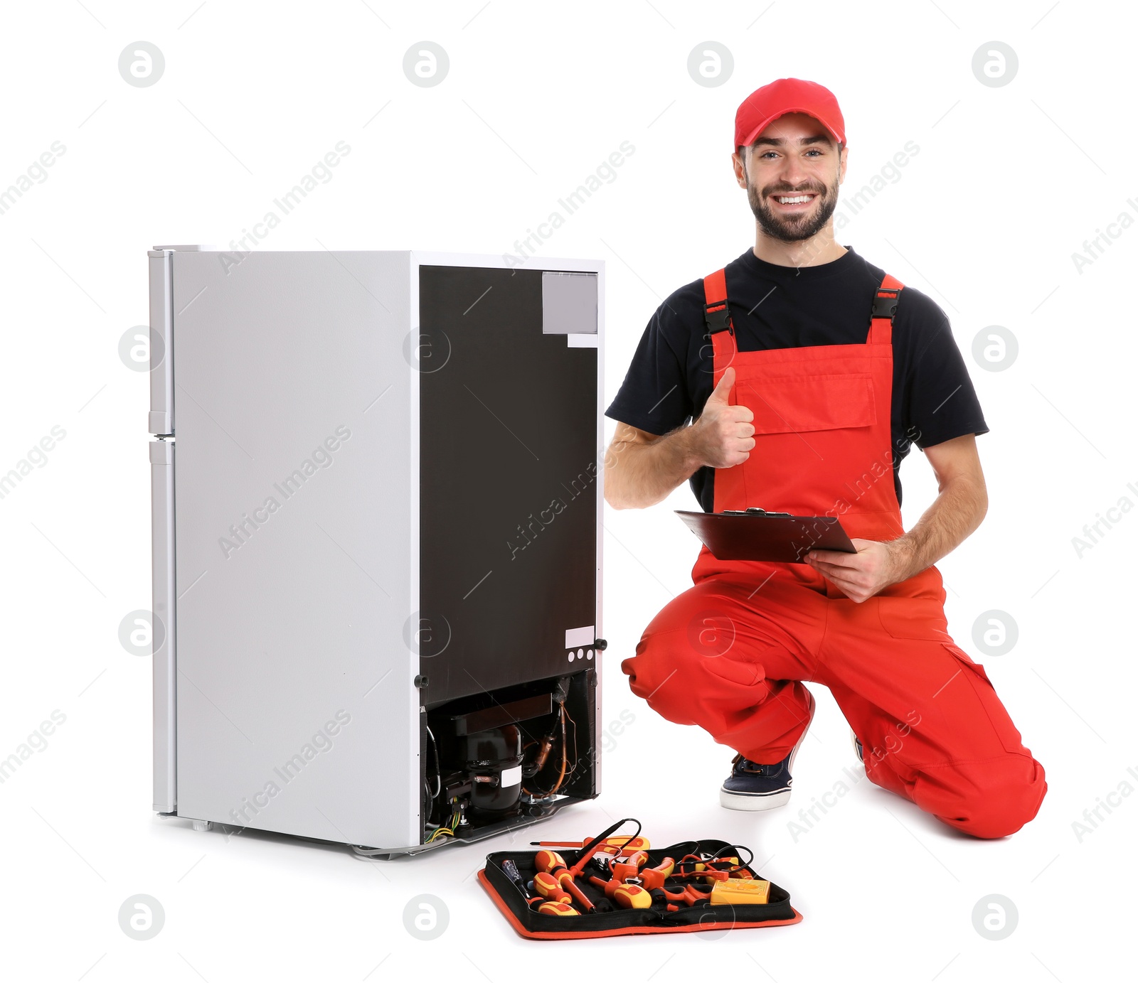 Photo of Male technician with clipboard and tools near broken refrigerator on white background