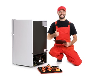 Photo of Male technician with clipboard and tools near broken refrigerator on white background