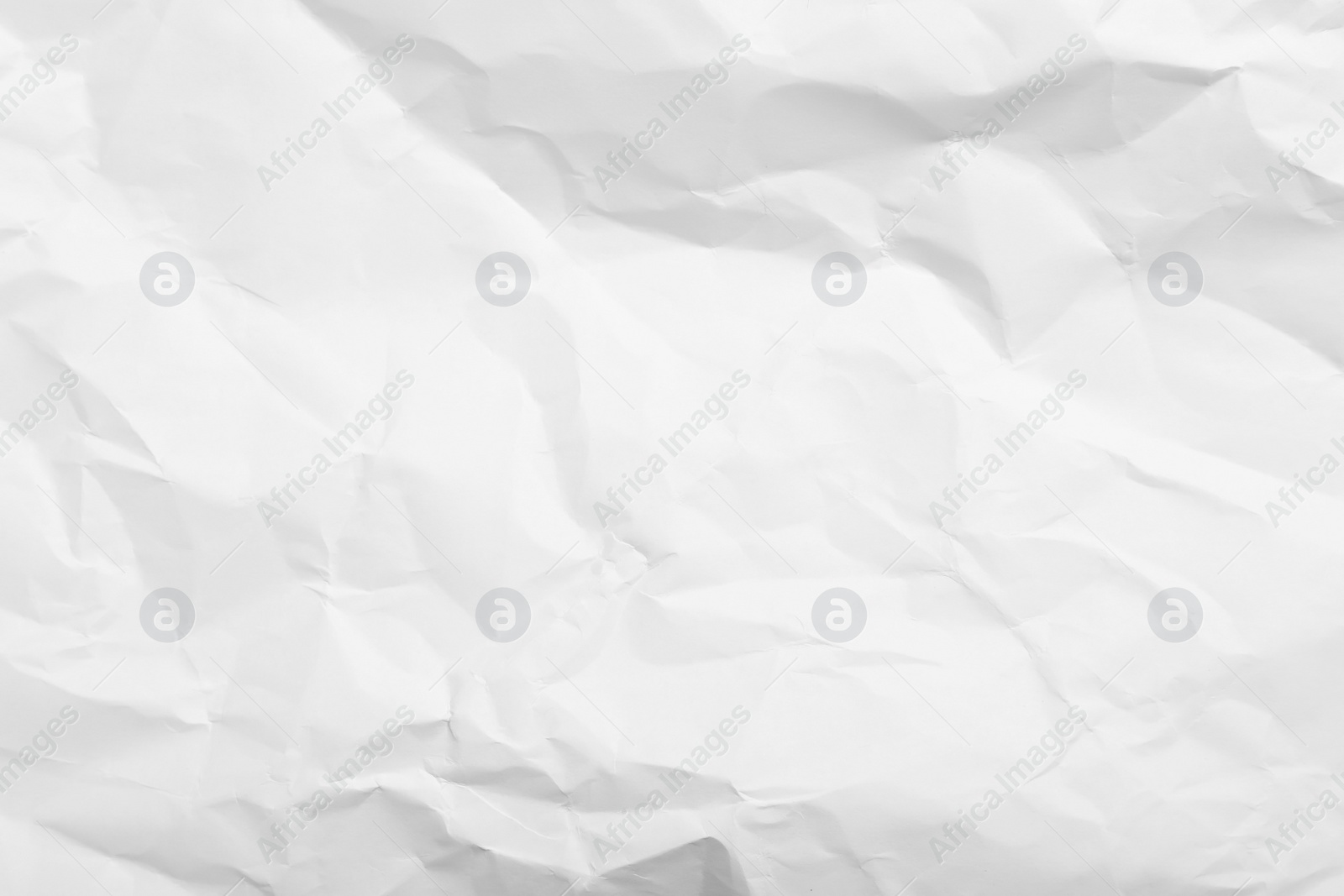 Photo of Sheet of white crumpled paper as background, closeup