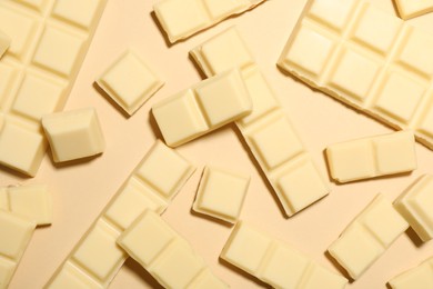 Delicious white chocolate on beige background, flat lay