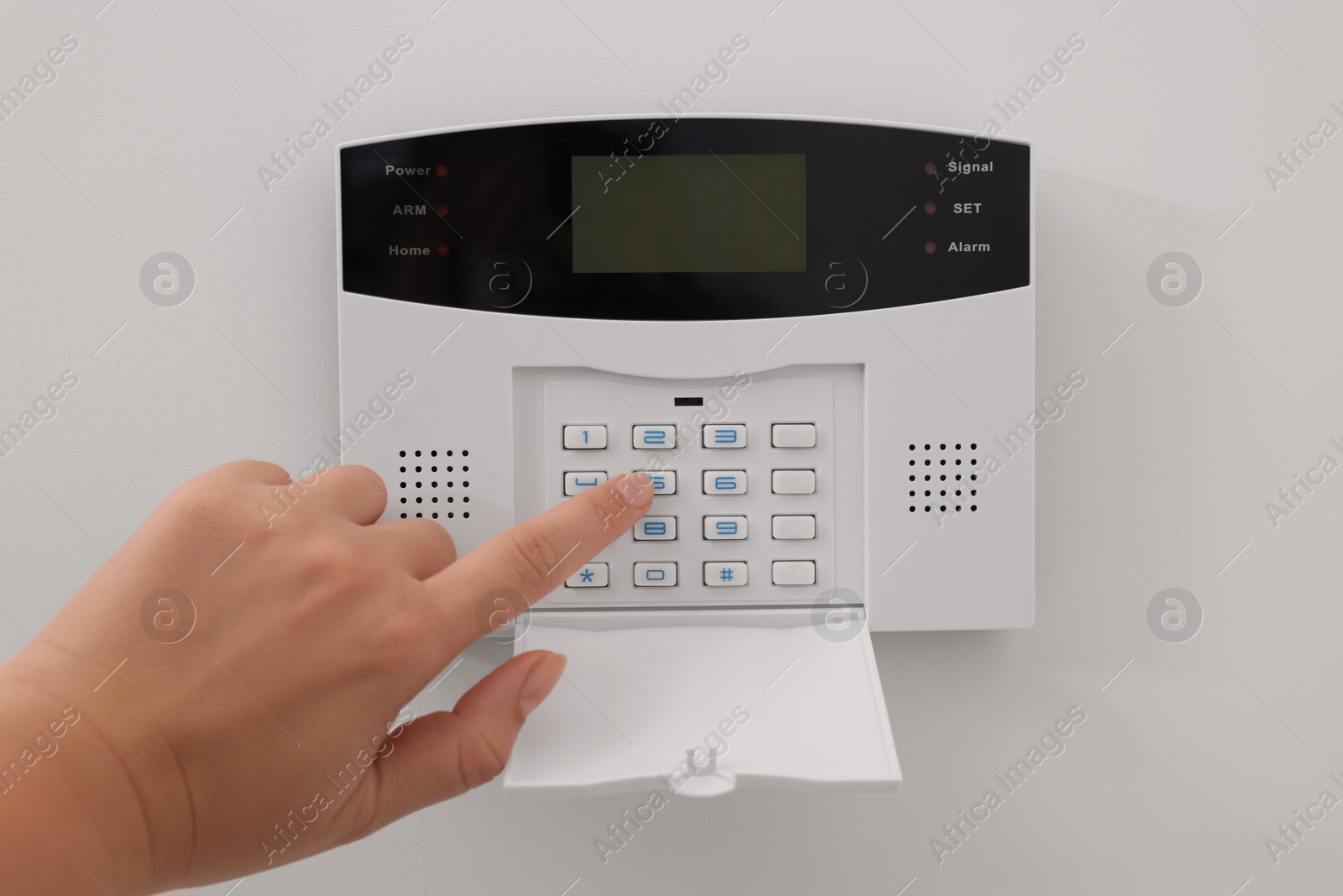 Photo of Woman entering code on home security system indoors, closeup