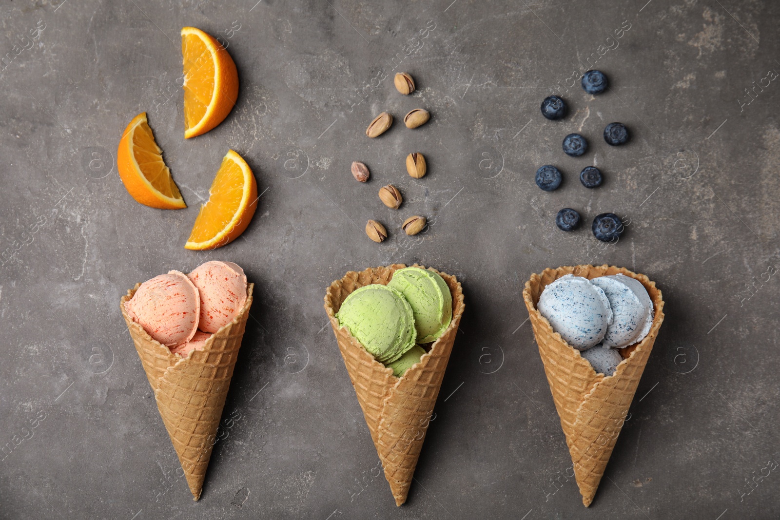 Photo of Flat lay composition with delicious ice creams in waffle cones on table