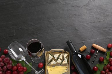 Photo of Tasty red wine and snacks on black table, flat lay. Space for text